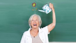 © contrastwerkstatt_adobe.stock.com Frau gießt mit einer kleinen Gießkanne eine Kunstblume auf ihrem Kopf