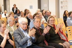 Teilnehmende der BAGSO-Fachtagung applaudieren. Zu erkennen sind Jens-Peter Kruse und Katrin Markus vom BAGSO-Vorstand, Franz Müntefering, der ehemalige BAGSO-Vorsitzende, und Nicole Zündorf-Hinte, Referentin im BMFSFJ. Klick öffnet eine vergrößerte Ansicht.