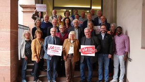 © BAGSO Eine Gruppe von Menschen steht auf einer Treppe. Einige von ihnen halten ein Schild mit dem Aufdruck "Ja zum Alter!" in der Hand.
