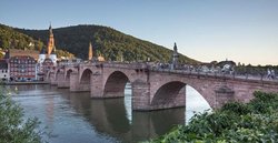 Eine alte Brücke über einen Fluss. Sie ist aus Stein und hat mehrere Rundbögen.