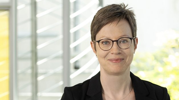 © BAGSO/Sachs Portrait Christina Münk: Frau mittleren Alters mit kurzen braunen Haaren, Brillenträgerin. Sie trägt eine schwarzen Blazer, darunter ein grünes T-Shirt. Sie schauf lächelnd in die Kamera.