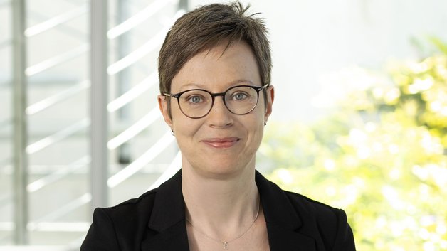 © BAGSO/Sachs Portrait Christina Münk: Frau mittleren Alters mit kurzen braunen Haaren, Brillenträgerin. Sie trägt eine schwarzen Blazer, darunter ein grünes T-Shirt. Sie schauf lächelnd in die Kamera.
