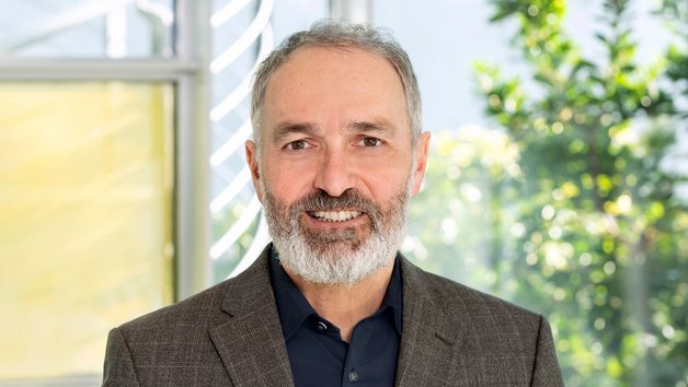 Protrait Dr. Guido Klumpp: Mann mittleren Alters mit Bart und Jacket.